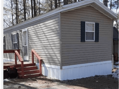 Mobile home exterior with skirting and entry deck